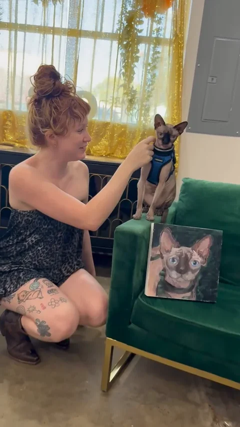An adult gently touching Harry as he stands beside a green upholstered chair